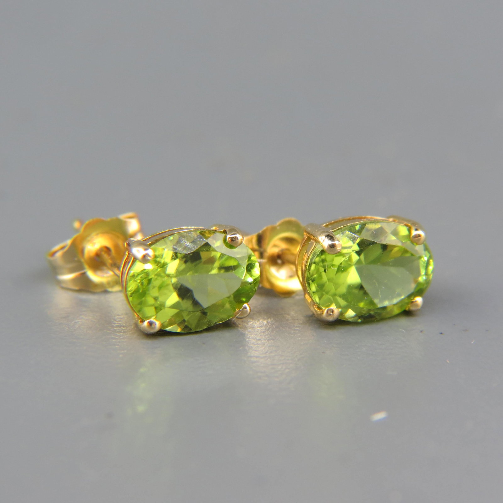 Peridot 14K Gold Earrings: Vivid oval gems totaling approx. 2 Carats in yellow gold pierced settings.