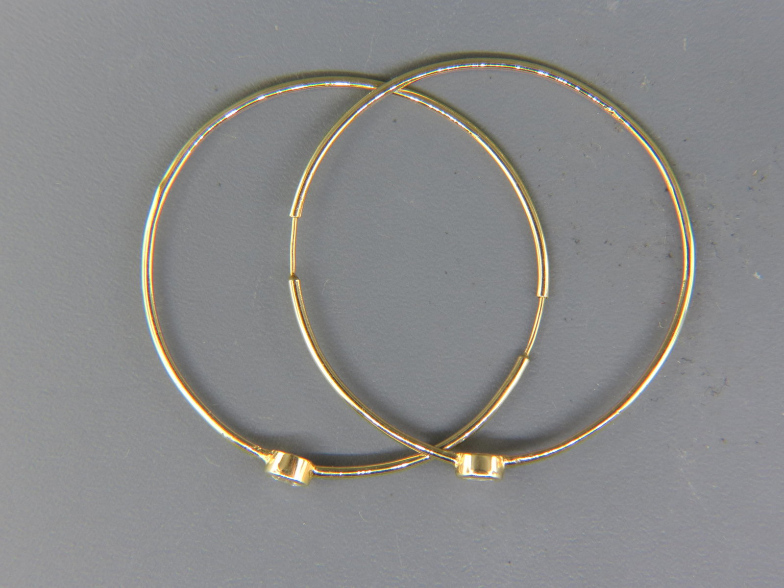 Pair of Diamond 14K Gold Hoop Earrings,: two round diamonds totaling .66 carat in 14K yellow gold, with appraisal of $2,625.00, 1 7/8" diameter.