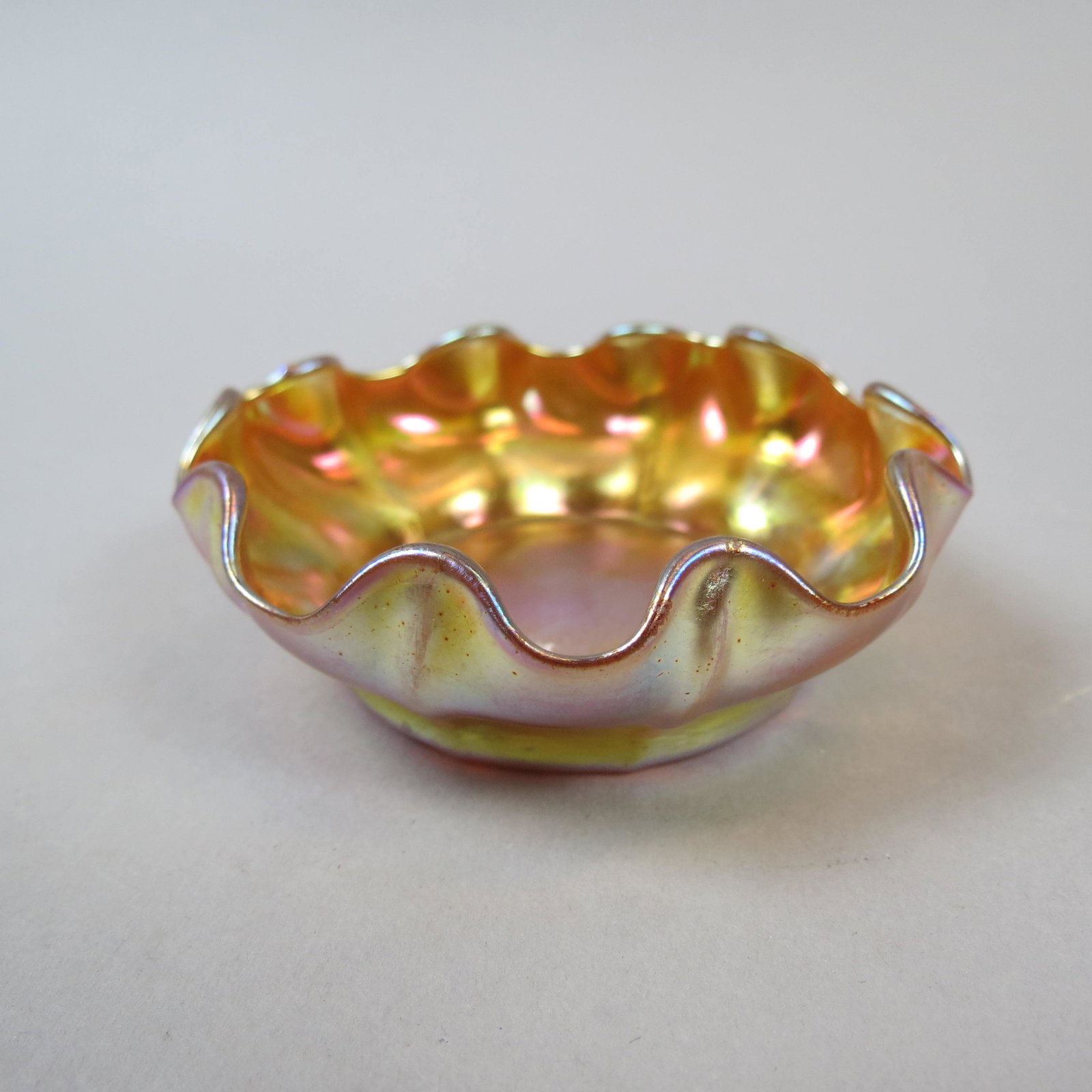 Tiffany Favrile Art Glass Salt Cellar: Rich golden iridescence with rich purple hues, floraform rim, 3 diameter, signed, excellent.