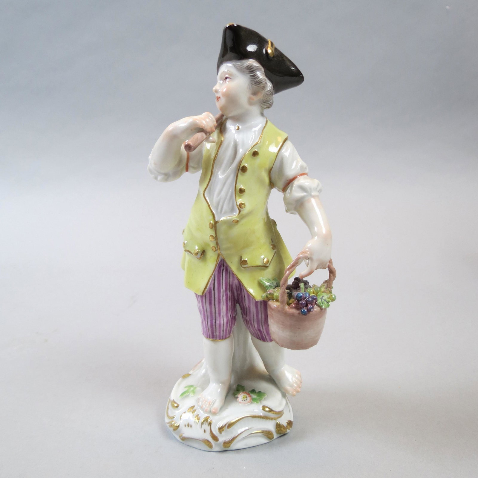 Meissen Porcelain Figurine Grape Harvesting Boy: With baskets of grapes, one lacking handle, 6 tall.