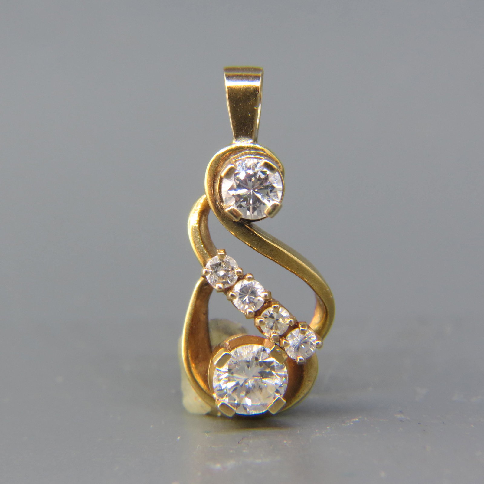 Diamond Pendant: 5 Round diamonds totaling .66 carat, 14K yellow gold, with appraisal of $2,250.00, 7/8 long.