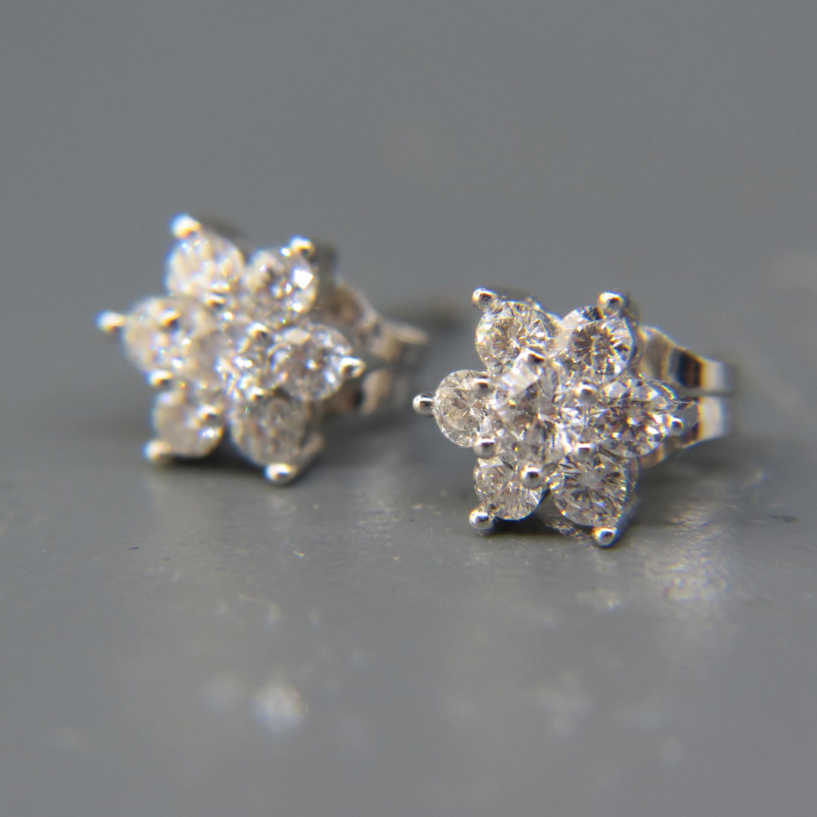 Diamond 14K White Gold Earrings: Each having 7 diamonds in flower style setting, total over .55 carat, 14K white gold, 7.5 mm across, pierced.