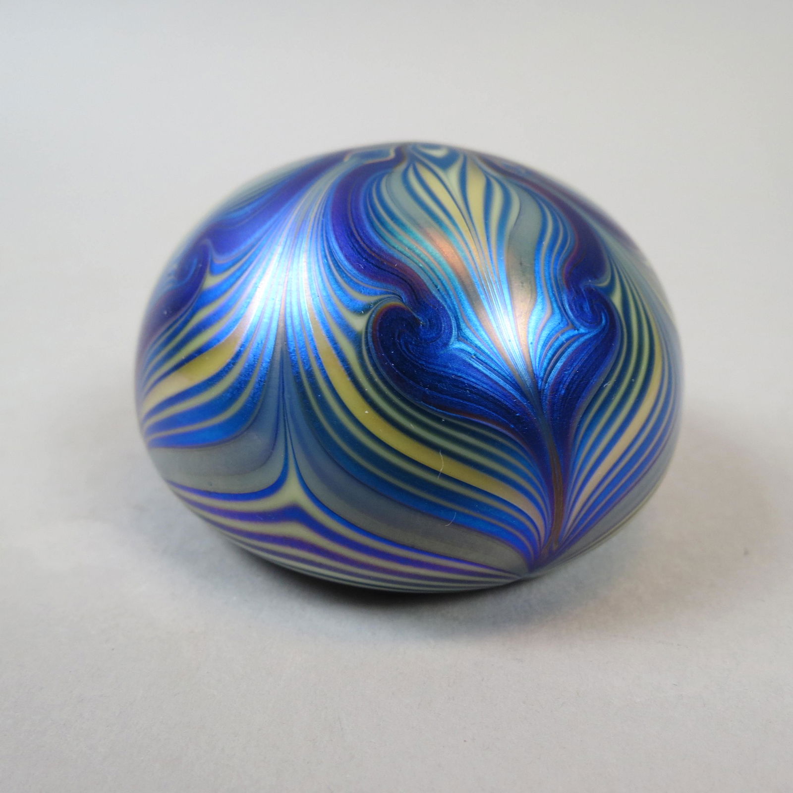 Orient & Flume Art Glass Paperweight: Iridescent blues and yellow feathered design, 2 1/2 diameter, signed and dated 1974, excellent.