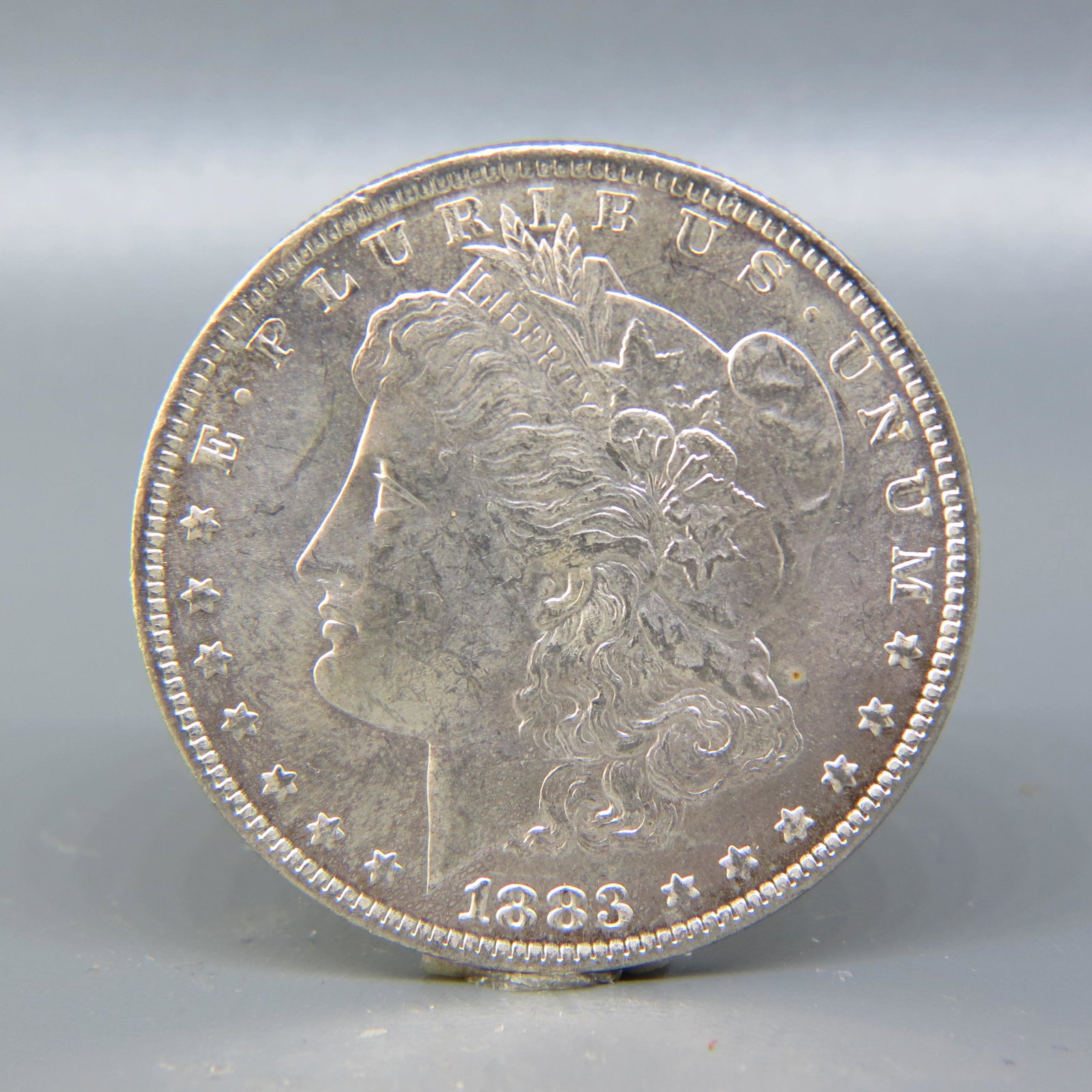 1883-O Morgan Silver Dollar, uncirculated,: light golden toning on obverse.