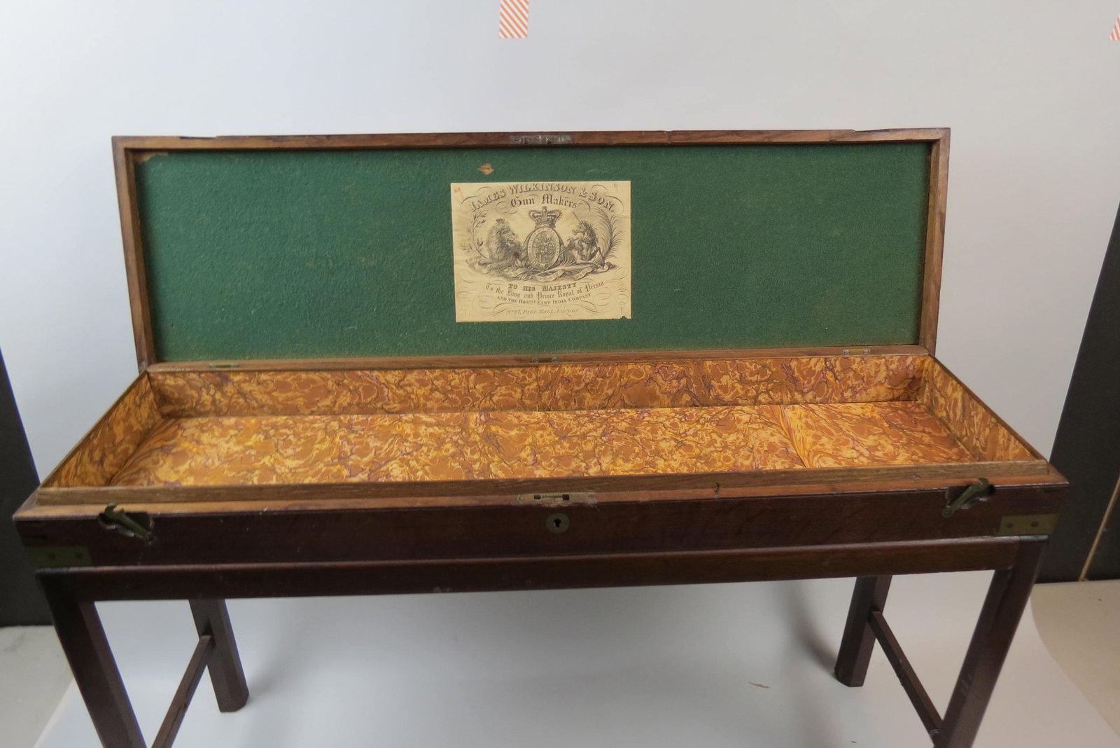 Antique English Gun Box, on Stand,: oak, brass inlay and corners, inner label of James Wikinson & Son, marbleized paper lined, hinged, 9 1/2" X 34", 3" deep, custom stand, overall 20" tall.