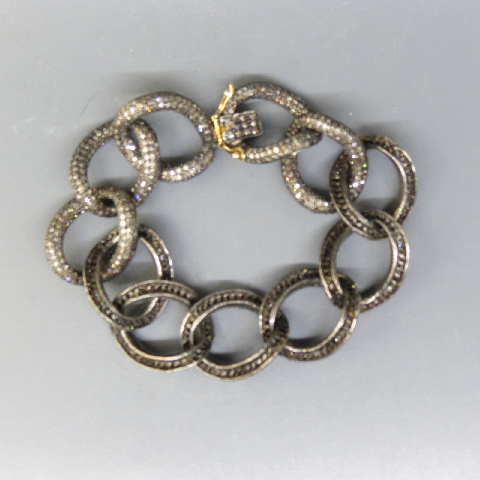 Diamond Bracelet 1680 Diamonds 10 Carats Total,: large silver links with black finish containing 1680 round diamonds in light champagne brown, gold at clasp, with appraisal of $5,750.00, 7 1/2" long.