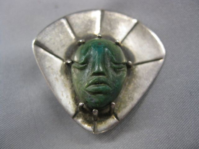 Sterling & Carved Stone Brooch, Aztec face, : Aztec face, by Winfred Clark Shaw, 1 1/4". Winifred Clark Shaw was an accomplished artisan and a highly regarded UNH professor, who taught jewelry, metalsmithing, and weaving here from 1954 to 1987. A