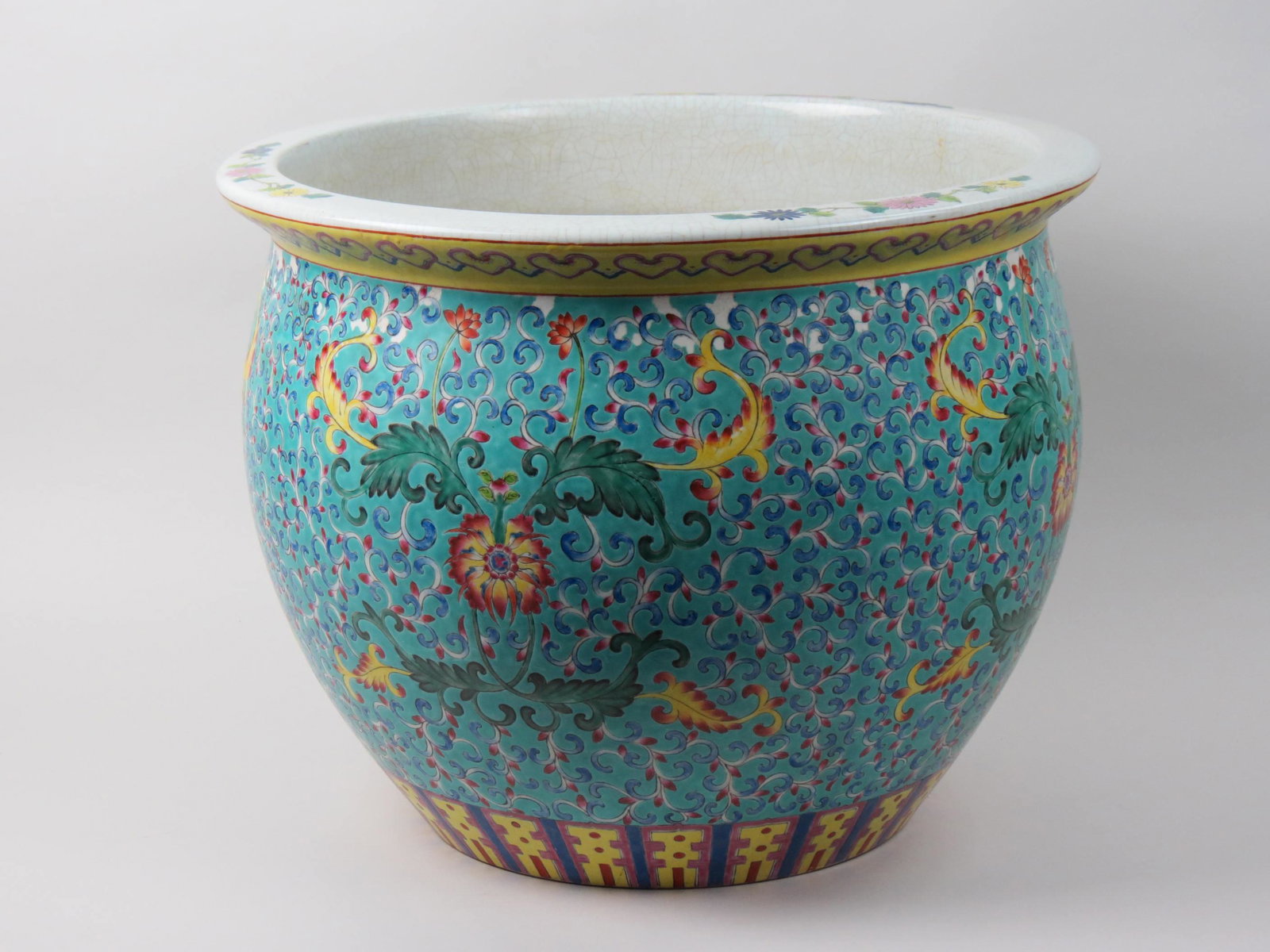 Chinese Famille Porcelain Fish Bowl Planter,: or jardiniere, floral designs on blue field, coy swimming design inside, 19" diameter, 15" tall, cracklure and flaking, an earlier example.