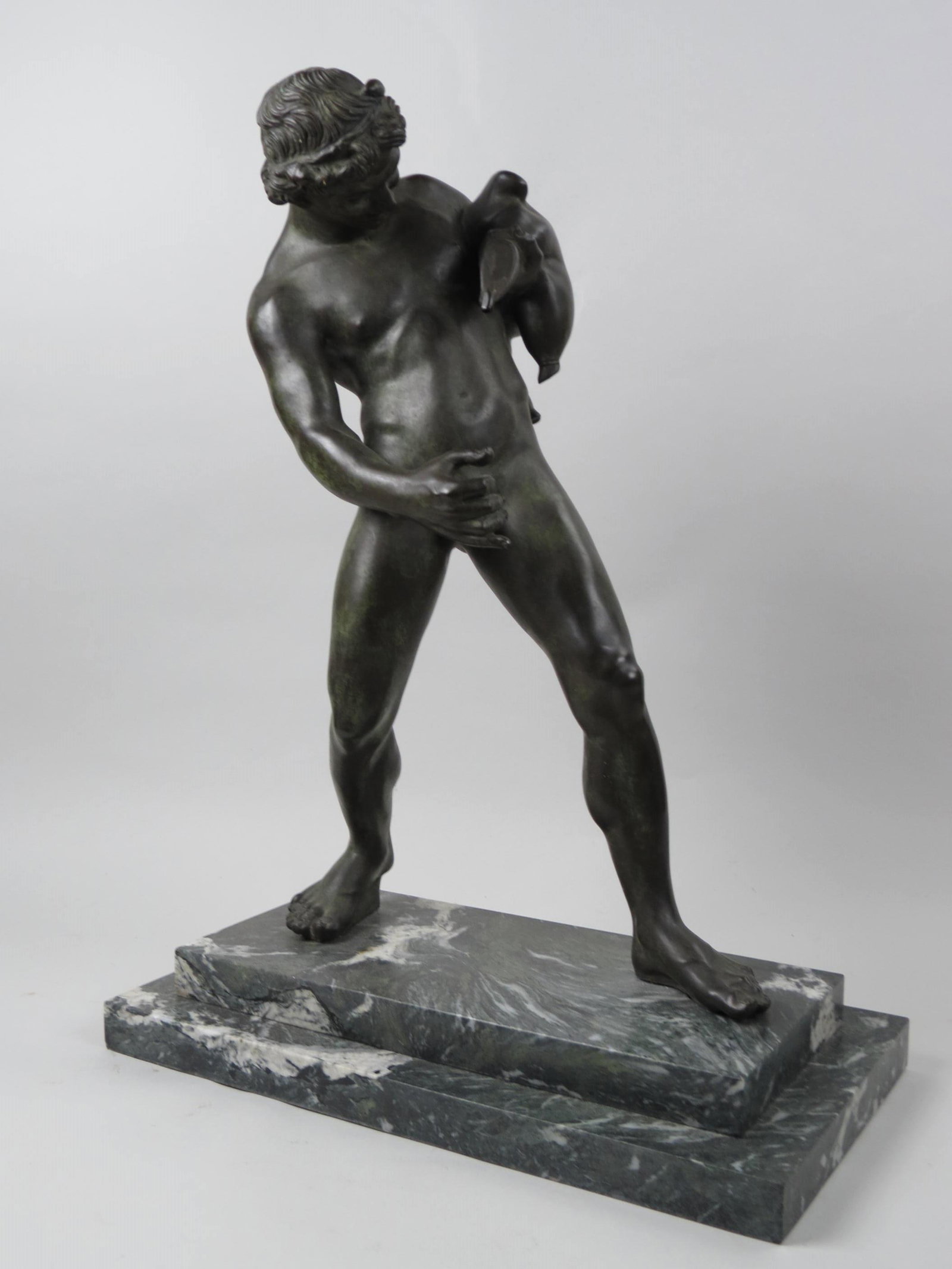 Bronze Nude Young Faun with wine sack,: holding a drinking vessel, originally a fountain, retains pipe inside if wished to be used a such again, on marble base, 22 1/2" overall, after Sommer, Naples.