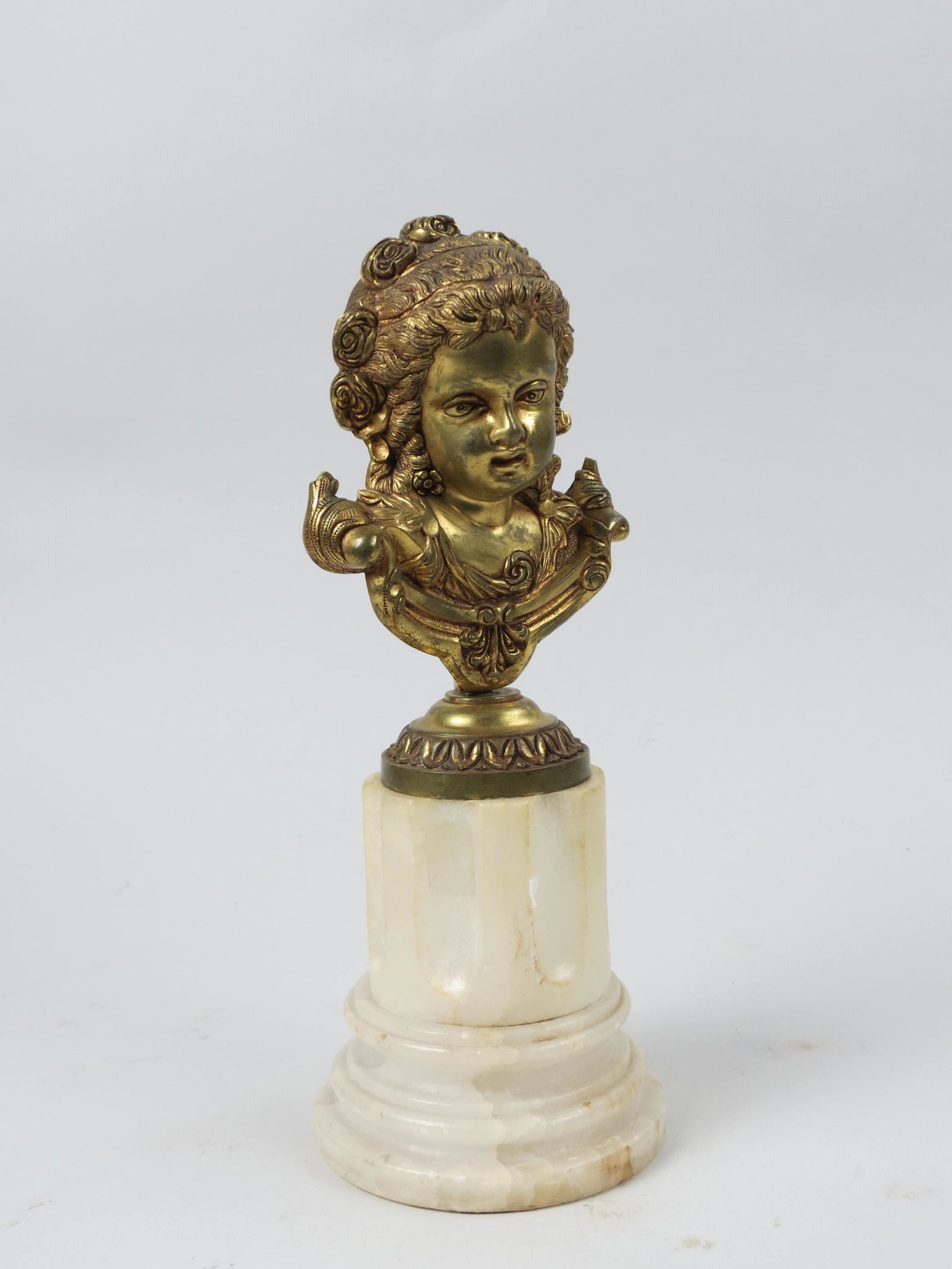 French Gilt Bronze Bust of a Young Girl,: flowers in her hair, on carved marble base, 12" tall.