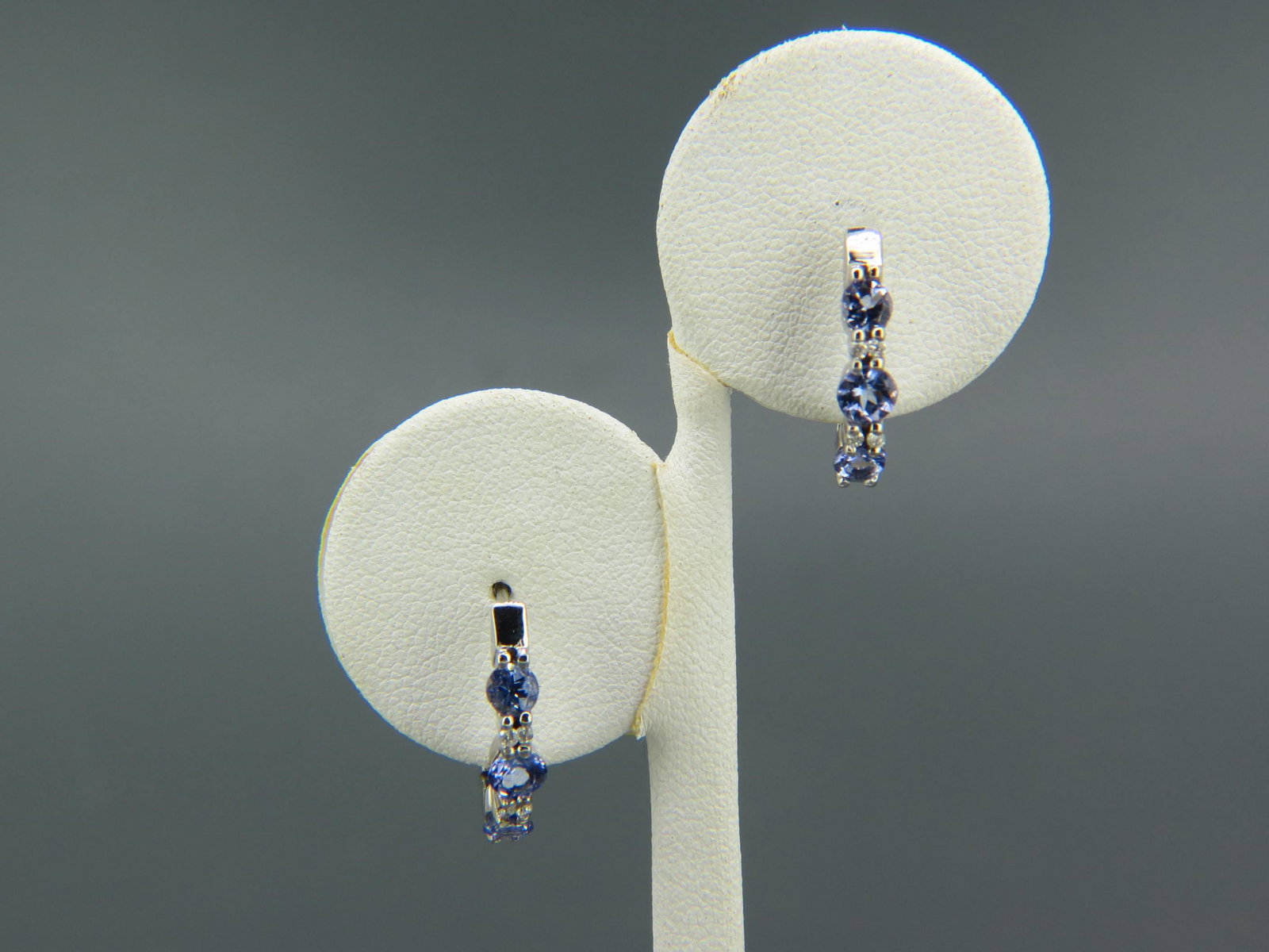 Tanzanite & Diamond Earrings,: 6 vivid round gems totaling 1.50 carats with 8 round diamonds totaling .08 carat, 14K white gold, with appraisal of $1,250.00, post and hinged hoop style.