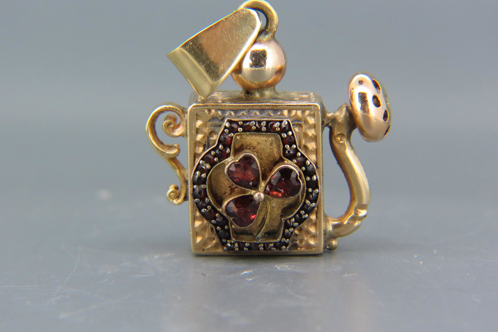 14K Gold & Garnet Figural Charm or Fob,: figural watering can set with rich red garnets in clover design, 13 grams, 1 1/2" long.