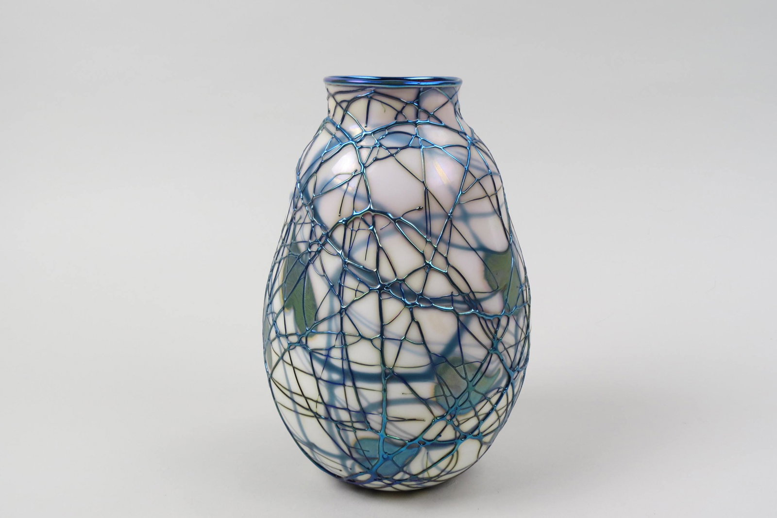 Charles Lotton Art Glass Vase,: iridescent trailing vine on white behind blue threading, red interior, signed, 8 1/2", excellent............Lotton Art Glass was founded in 1970 by self-taught glass artist Charles Lotton. In the begi