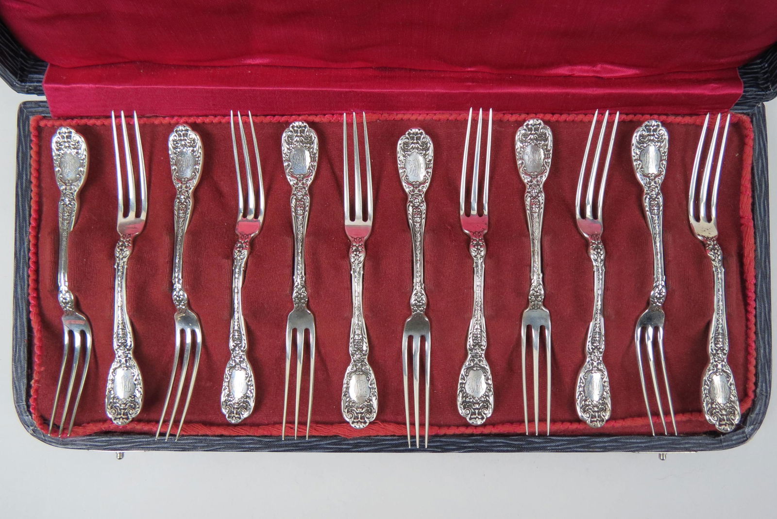 12 Gorham "Florentine" Sterling Strawberry Forks,: 1901, 4 1/2", fancy monogram, 208 grams, in original case.