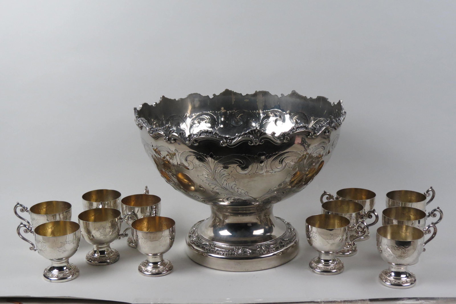 Silverplate Punchbowl and 12 Matching Cups,: hand chased floral, fancy scalloped rim 16" bowl, pedestal base, 11 1/2" tall, along with 12 matching pedestal cups.
