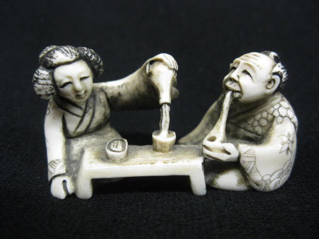 Chinese Carved Ivory Netsuke of Seated man & woman: man & woman having tea, 2" x 1", signed, excellent