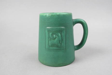 Rookwood Pottery Mug by Albert Munson, 1901,: Arts & Crafts style green matte glaze with stylized ram's head in panel, shape #345CZ, 4 1/2", excellent........Albert Cyrus Munson ("Bert") designed pieces at Rookwood Pottery for fifty-four