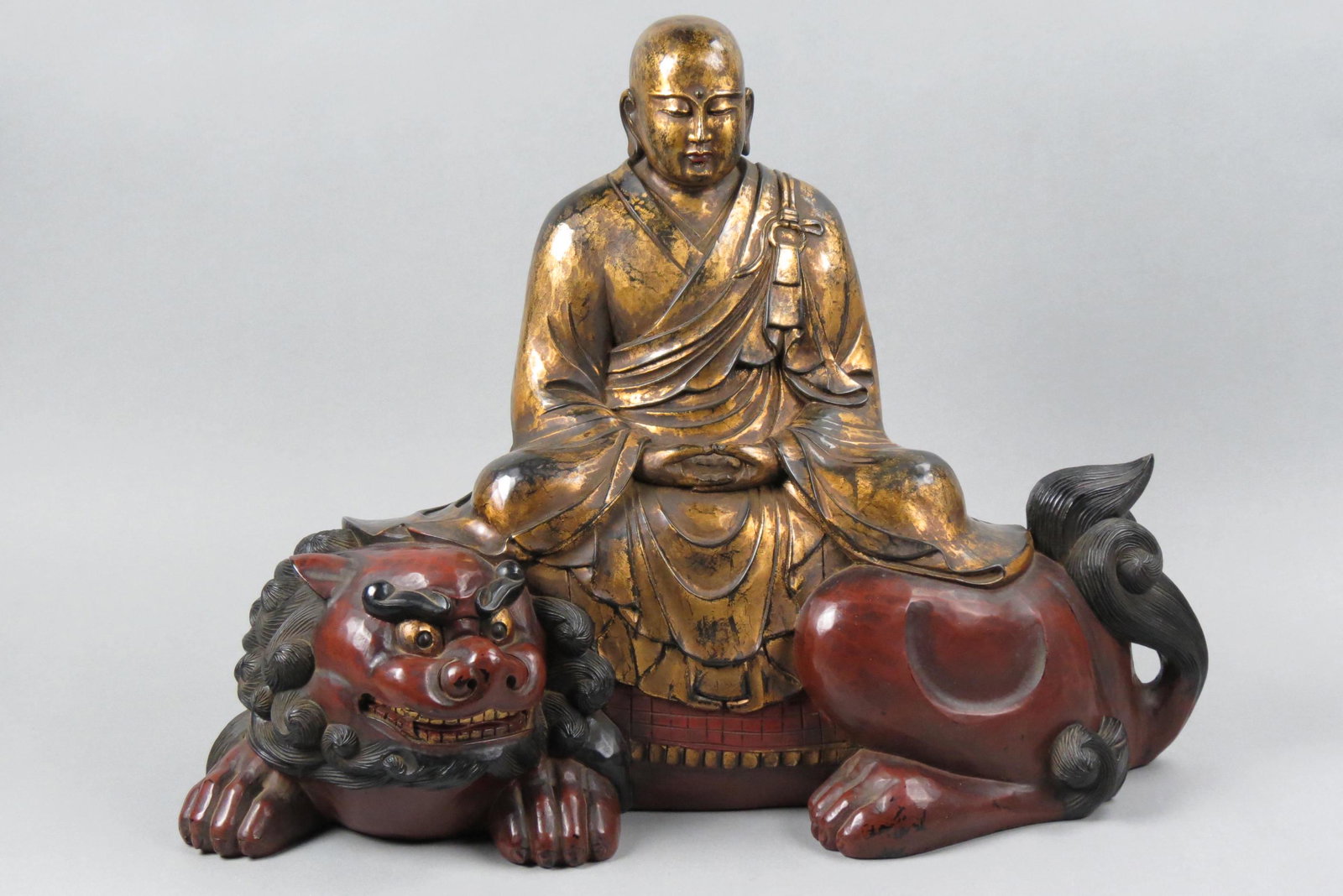Japanese Carved Monju or Buddha on a Shishi,: gilded, lacquered and painted, Edo/Meiji period, 17 1/2" tall, 23" long, 10 1/2" deep.