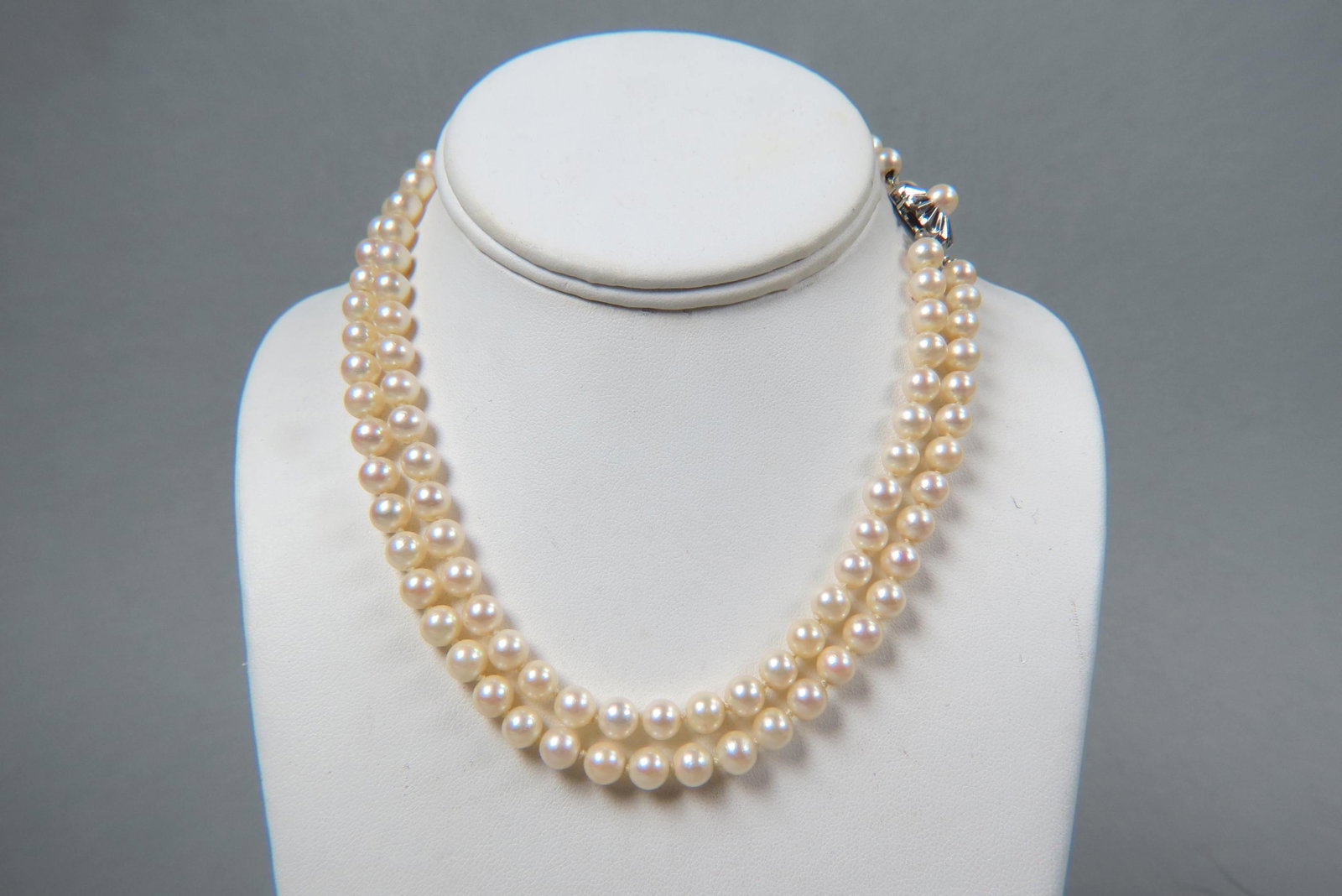 Pearl Necklace, double strand,: with 106 pearls measuring 6.5 to 7 mm with cream pink overtunes, 14K white gold floral clasp, with appraisal of $1,250.00, 16" long.
