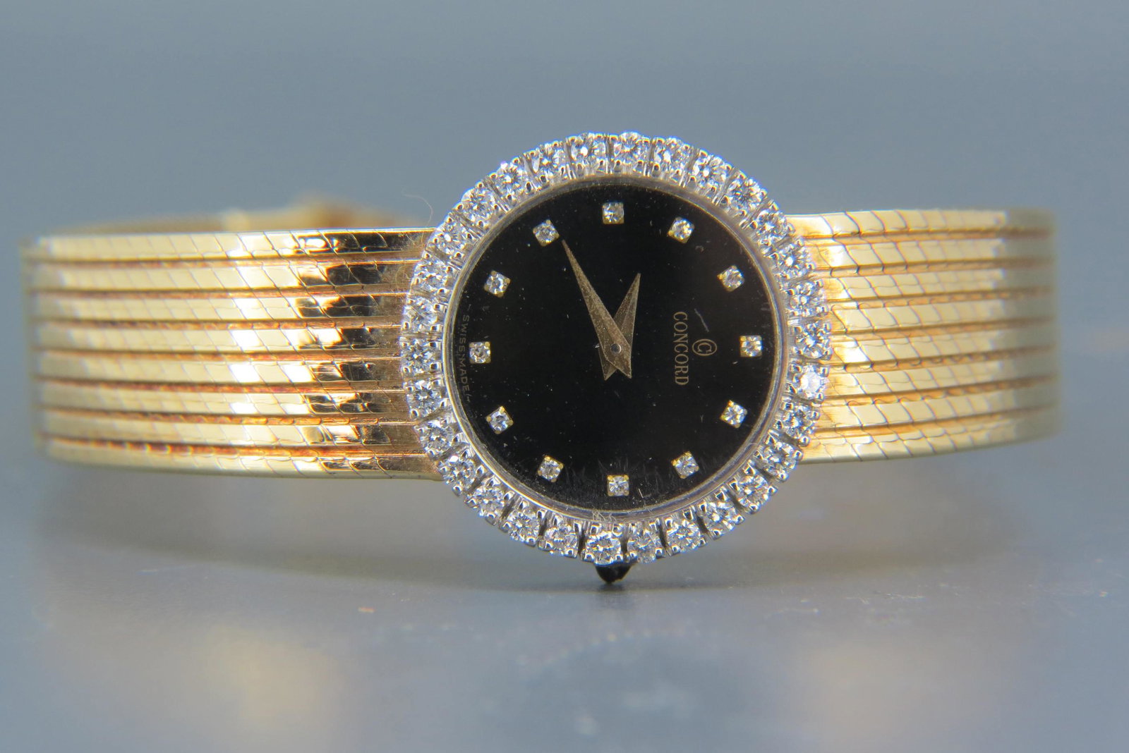 Ladie's Concord Diamond 14K Gold Wristwatch,: 33 round diamonds around black dial with diamond markers, 14K yellow gold case and band, sapphire crown, 35.5 grams, 6 1/2" long, working