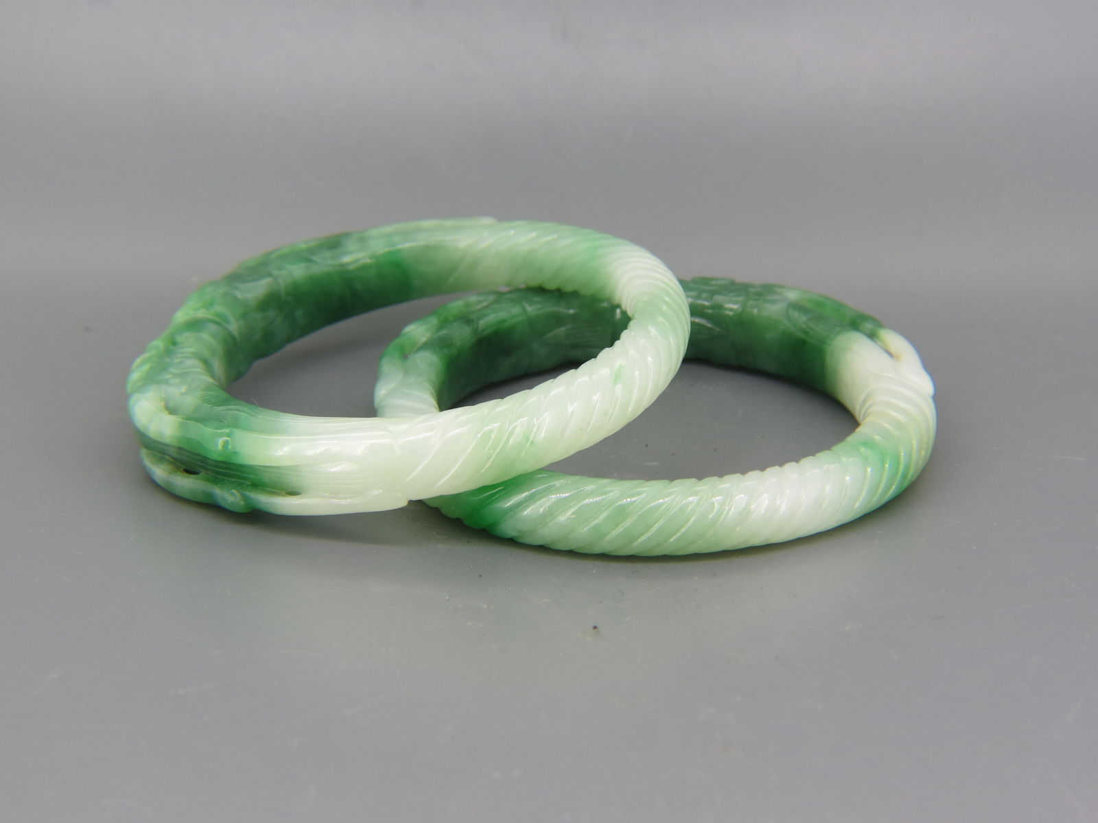 Pair of Chinese Carved Jade Bangle Bracelets, mottled greens and white, carved dragons, twist  decor (1 of 3)