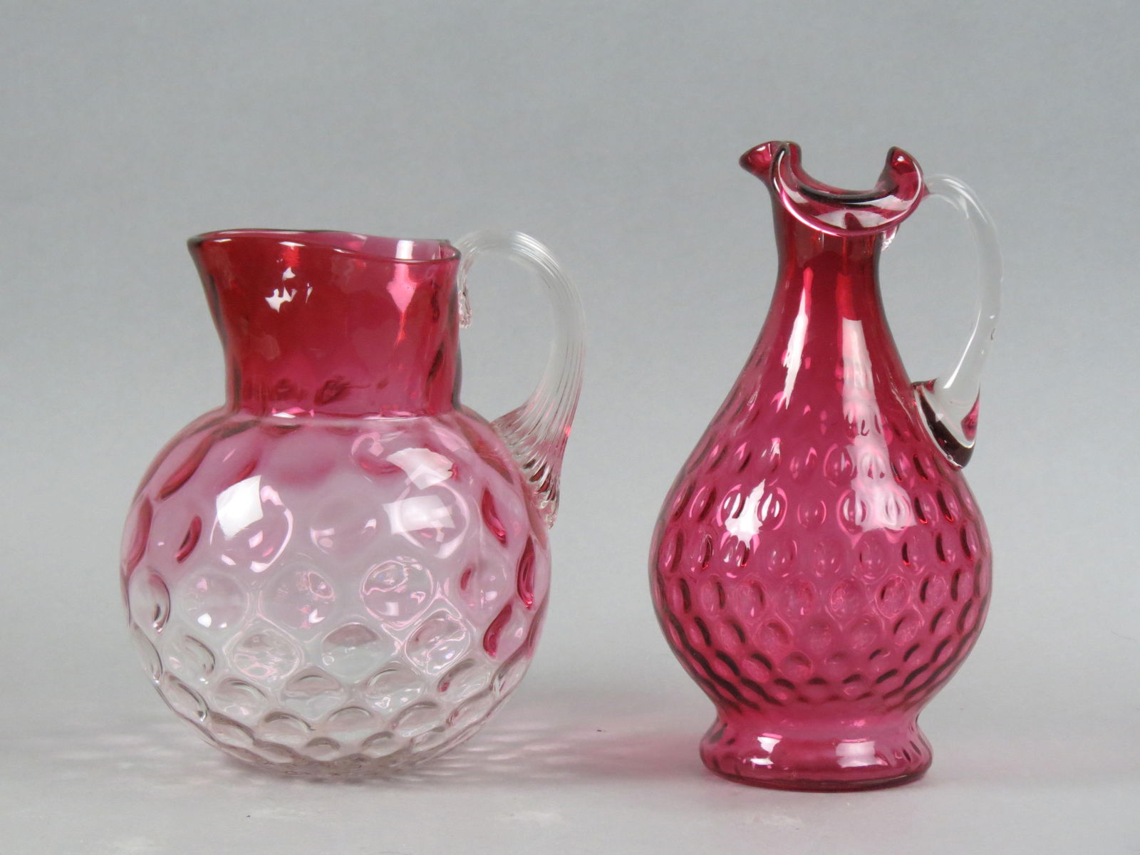 2 Cranberry Glass Pitchers, one with coin spot decor attributed to Mt.  Washington (8 3/4"), other (1 of 3)