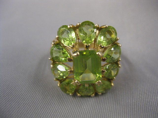 Peridot Ring, emerald cut gem: surrounded by 10 pear shaped gems totaling 4 carats in 10k yellow gold, currently sized 7-3/4, 6.2 grams.