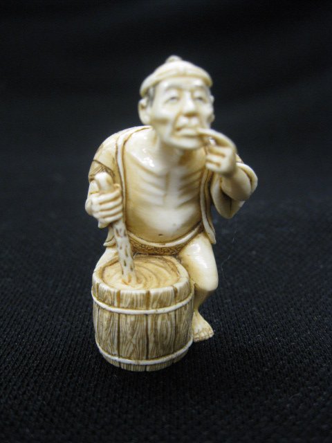 Carved Ivory Netsuke of a Man stirring a pot, sam: stirring a pot, sampling the contents, 1 7/8", signed, excellent.