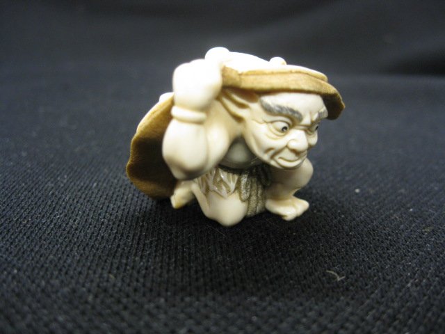 Carved Ivory Netsuke of a Oni in a large hat, fin: in a large hat, fine brown polychrome detail, 1 1/2", signed, excellent.