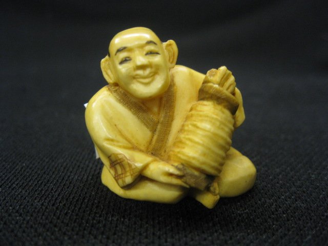Carved Ivory Netsuke of a Seated man, with accord: with accordian, 1 1/4", signed, excellent.