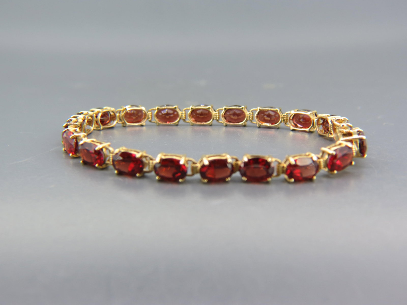 Garnet & 14K Gold Bracelet, 20 rich oval gems.: totaling approx. 15 carats, 14K yellow gold, 9.6 grams, 7" long.