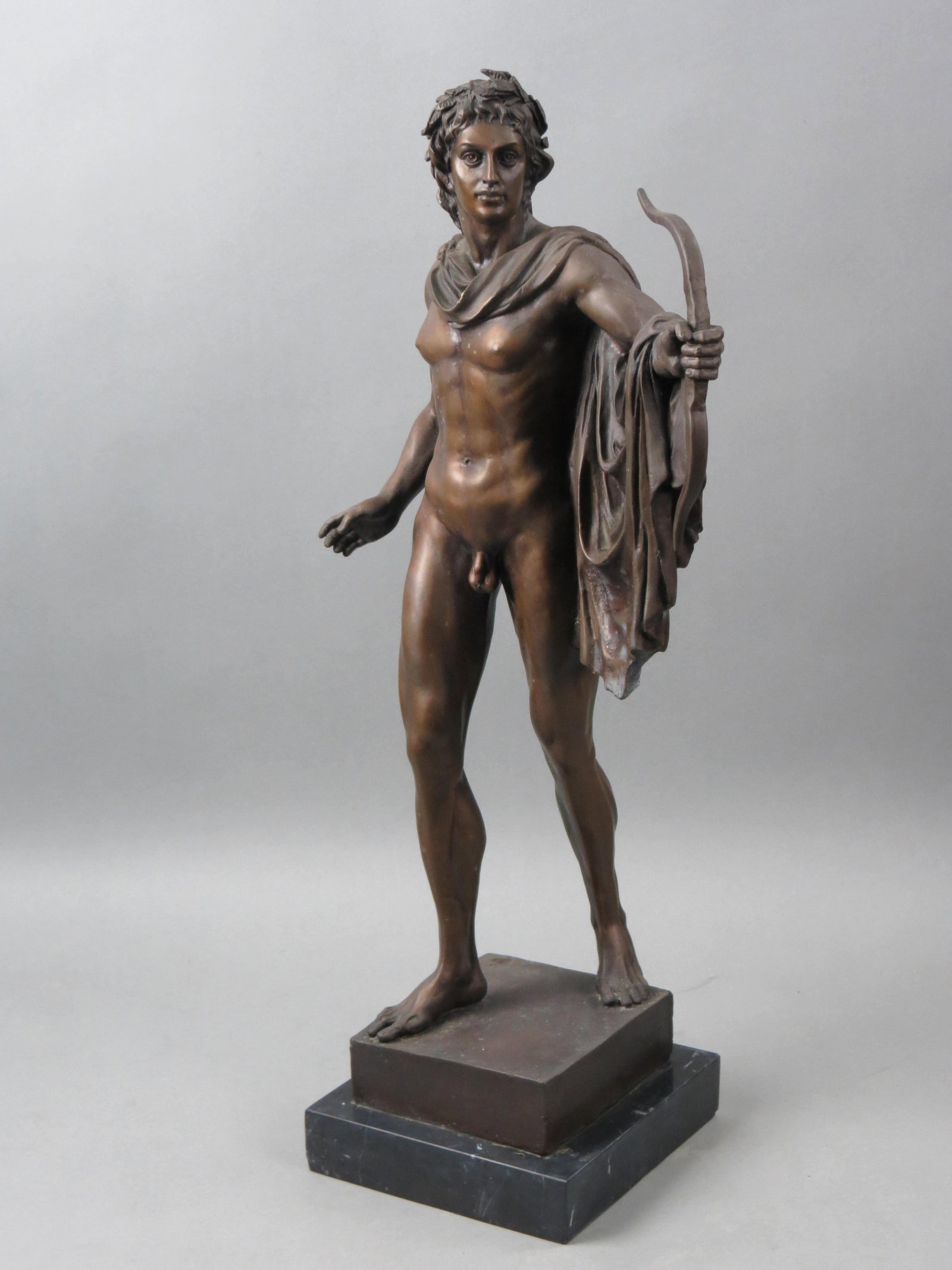 Bronze Statue of "Apollo" Classical Male Nude,: with bow and robe, black marble base, 25" tall, unsigned......Apollo, “apolloin Greco-Roman mythology, a deity of manifold function and meaning, one of the most widely revered and influential of all