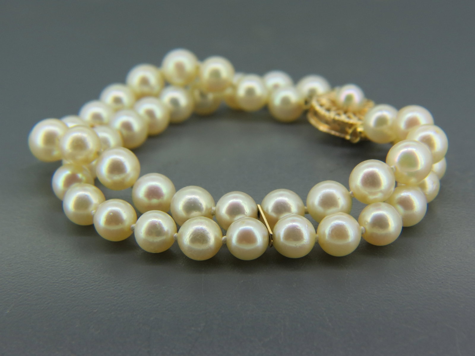 Pearl Bracelet, double strand with 44 pearls,: measuring 6 to 6.5 mm, 1K yellow gold clasp and spacer bars, 16.4 grams, 6 1/2" long.