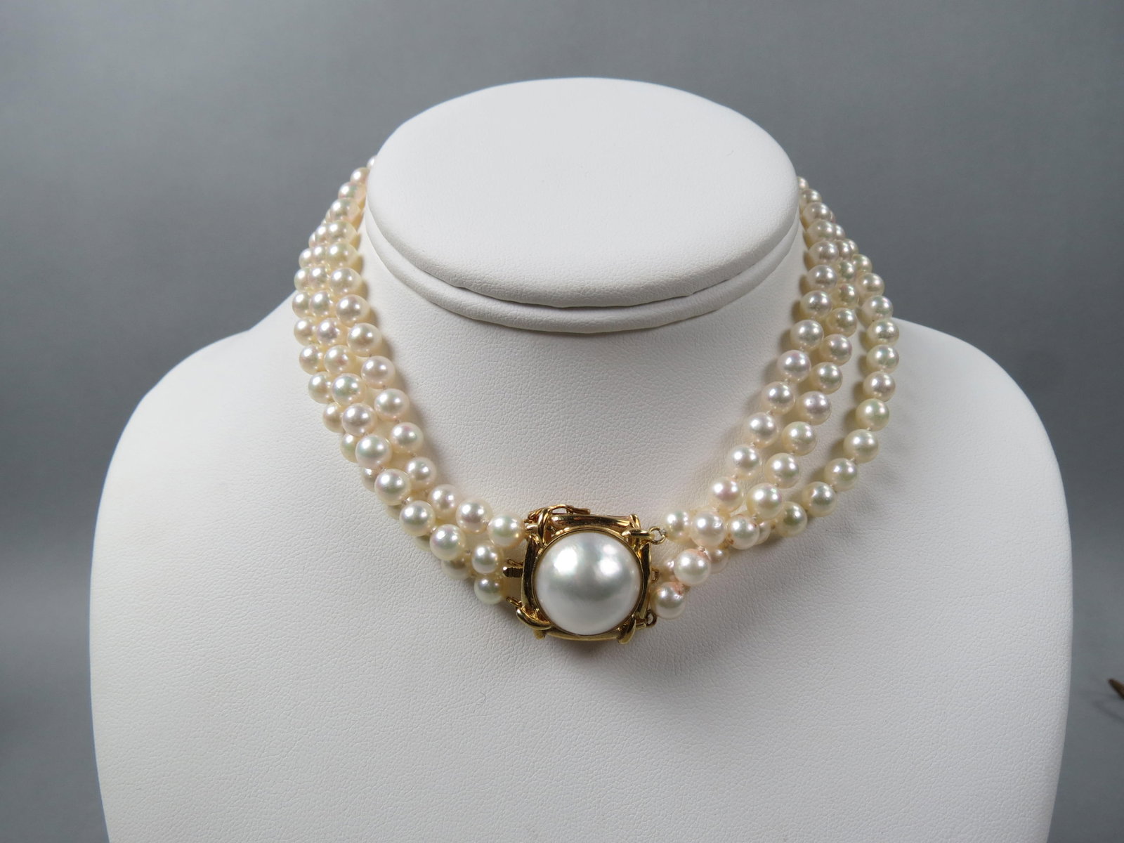 Pearl & 14K Gold Necklace, triple strand,: 150 fine light cream and pink lustrous pearls measuring 5.5 to 6 mm, with a fine 17 mm Mabe pearl in heavy 14K yellow gold clasp, with appraisal of $1,850.00, 14" long.