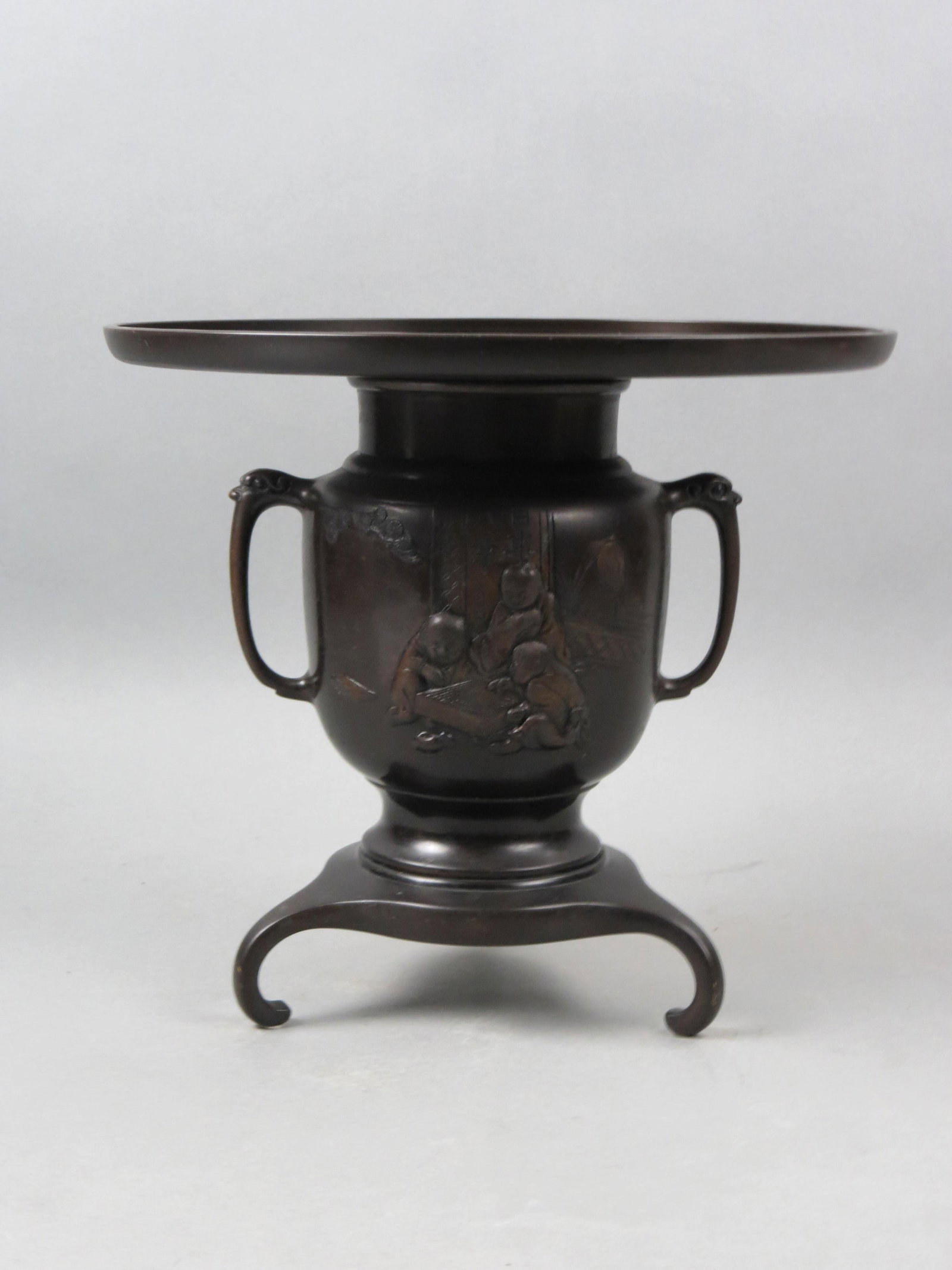 Japanese Bronze Ikebana Vase,: Meiji period, scene with figures playing a board game, tri-footed, 3 part body, 10 1/2" tall, 12" diameter.