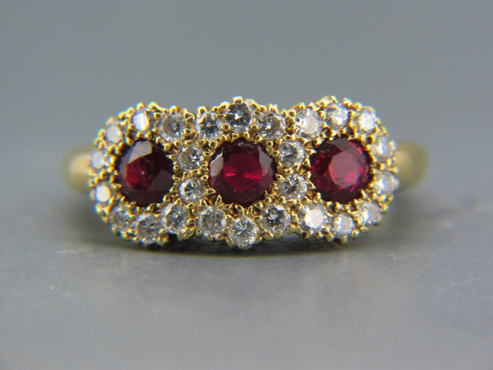 Ruby & Diamond Ring,: 3 round rubies totaling 1.00 carat and 26 round diamonds totaling .75 carat in 18K yellow gold, high grade, with appraisal of $5,350.00, currently size 6 1/2.