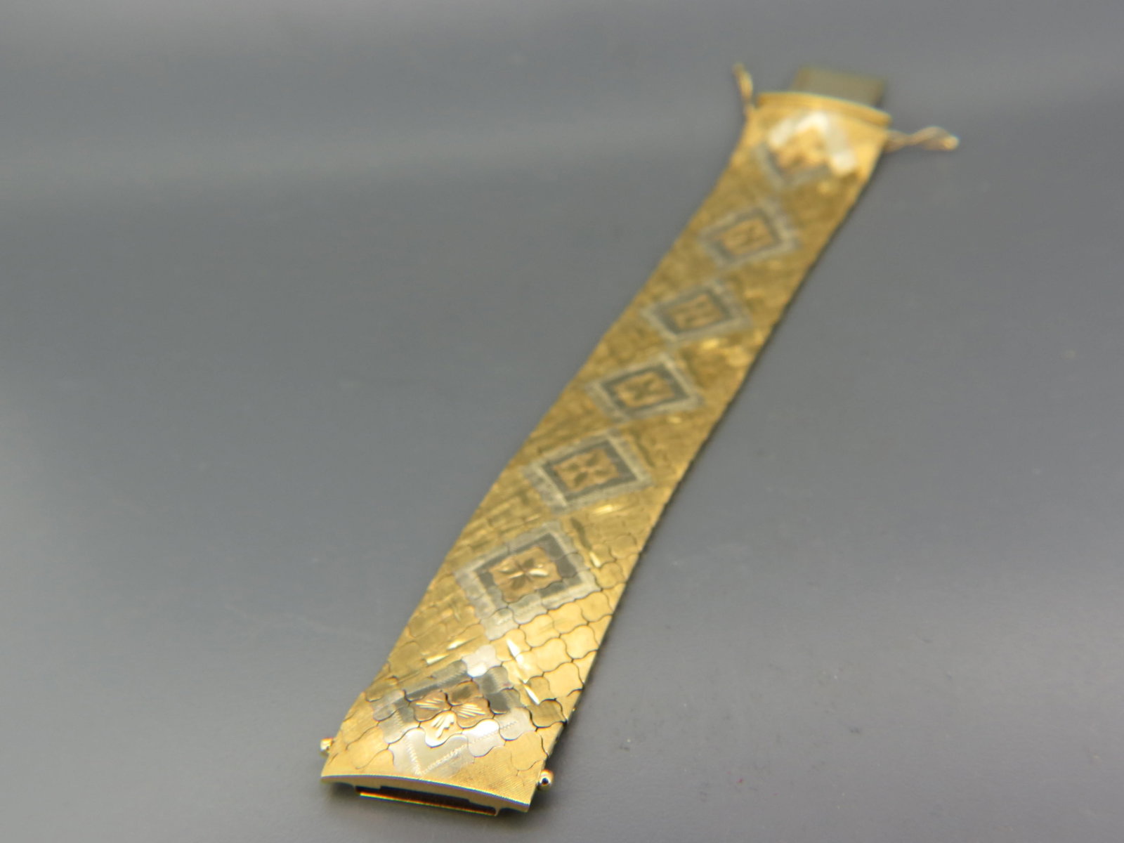 18K Gold Wide Bracelet, mid-century,: yellow flowers in white gold triangular designs on yellow gold field, 1" wide, 7 1/2" long, 72 grams (2 ounces).