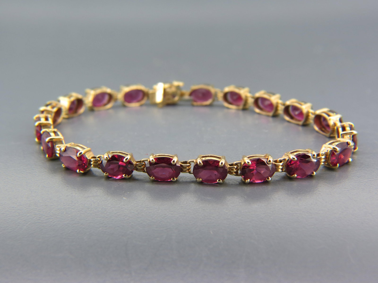 Rhodalite Garnet & 14K Gold Bracelet,: 20 oval gems totaling approx. 20 carats in straight line or tennis tyle 14K yellow gold setting, 10 grams, 7 1/2" long.