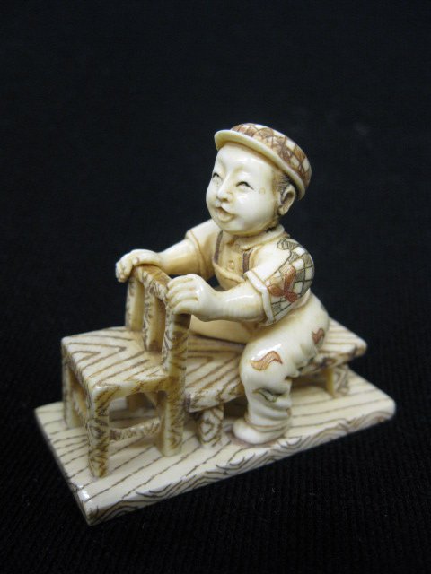 Carved Ivory Netsuke of a Seated Boy,: fancy polychrome, signed, 2".