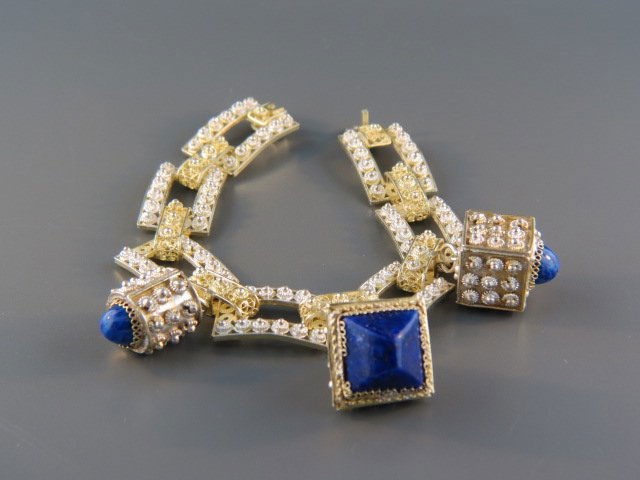 Sterling Silver Charm Bracelet,: gold trim, a trio of fobs or charms, blue stones, 7" long, hallmarked.