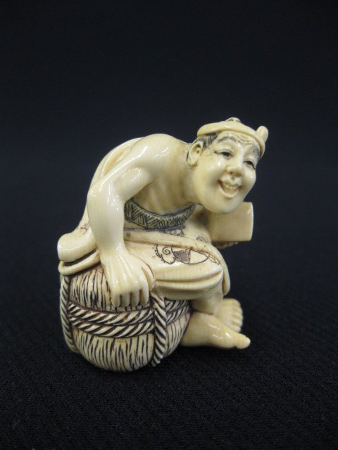 Carved Ivory Netsuke of a Man,: seated on a rice bak, bag over his back, signed, 1 1/2".