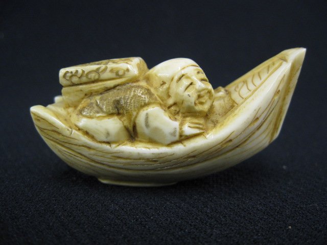 Carved Ivory Netsuke of a Man in boat,: back pack on back, signed, 2".