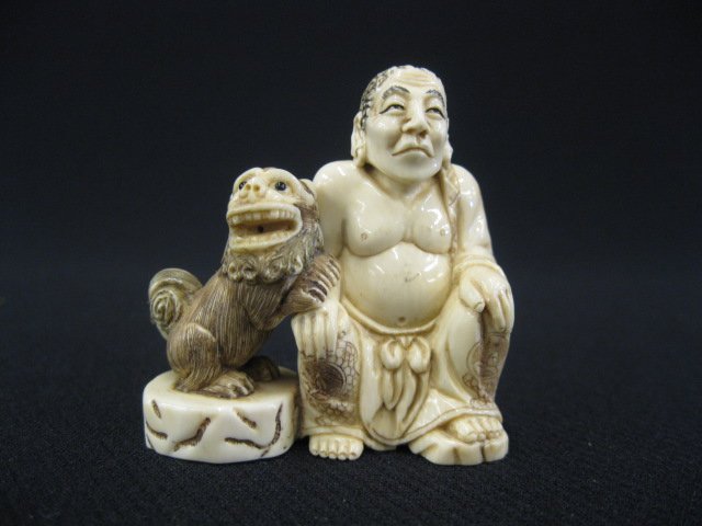 Carved Ivory Netsuke of a Seated Lohan,: with foo dog at his side, signed, 2".