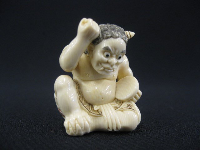 Carved Ivory Netsuke of a Seated Oni,: playing a drum, fine detail & polychrome work, 1 5/8", signed.