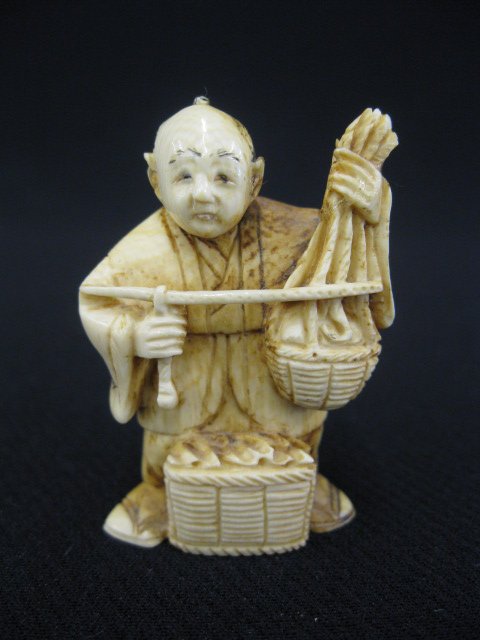 Carved Ivory Netsuke of a Farmer,: with two baskets of vegetables, holding a scale, signed, 2".