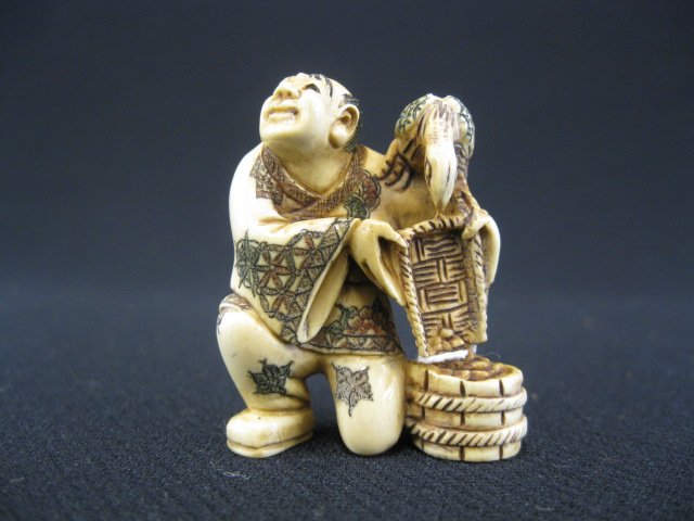 Carved Ivory Netsuke,: man with bird & bucket, polychromed, signed, 1 5/8".