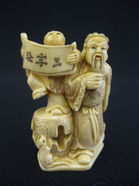 Carved Ivory Netsuke of a Bearded Man,: with child holding a stool, signed, 2'.