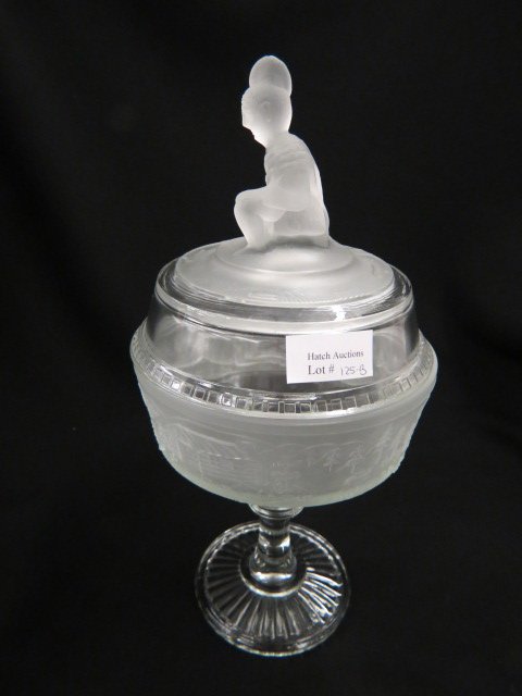 "Westward Ho" Pattern Glass Compote,: Indian finial, 12", excellent....A clear pressed glass with frosted relief designs comprising a pioneer’s log cabin with charging buffalo and fleeing deer in scenes of mountain and plain, Westward H