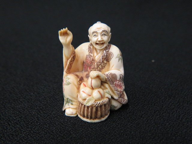 Carved Ivory Netsuke of a Seated Man,: with basket of peaches, 1 5/8", fancy polychrome trim, signed, excellent.