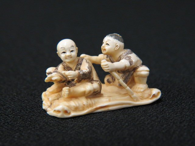 Carved Ivory Netsuke of Two Boys,: on a bamboo raft, 1 3/4" long, signed, excellent.